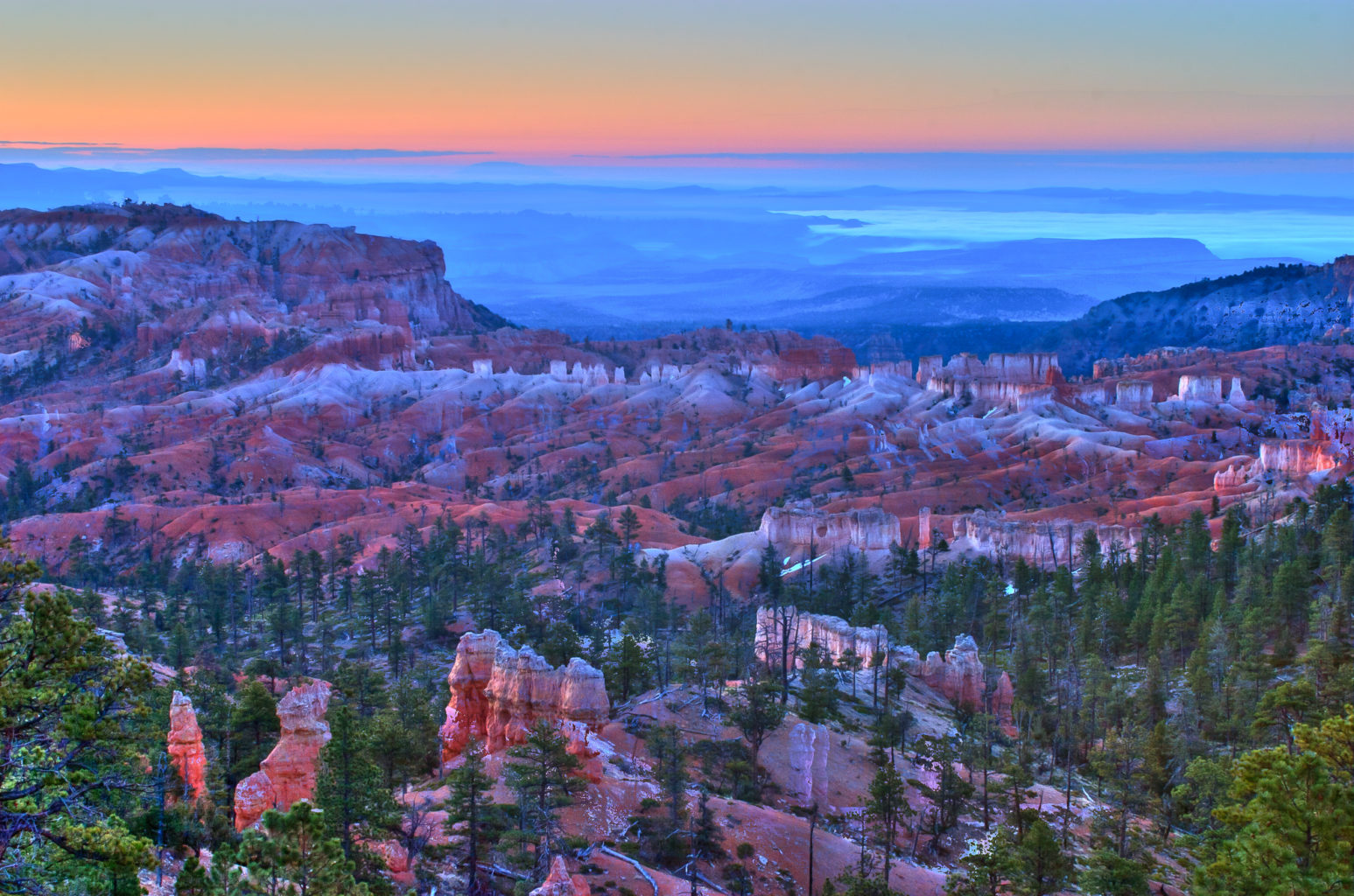 Bryce Canyon, Utah.This image was part of a set that I worked hard to photograph. I recall waking up at about 3:30AM, arriving at the foot of the canyons around 4AM and hiking in pitch-dark to get to the spot (forgot to carry a flashlight!). I had taken this image when my eyes could barely see over the horizon. This is the effect of accumulating light over 30 or more seconds! The best part of hiking back at about 7AM (besides being able to see where we were going) was that we saw other photographers hiking up to the spot where we stood a few minutes ago. By then, the light level was too bringht to capture the suble colors and snow. The early bird indeed got the worm!